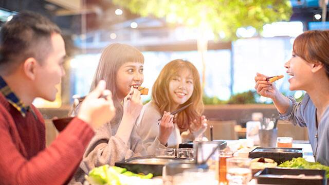 一位笑得燦爛的女性在對著鏡子刷牙