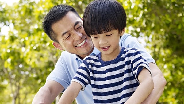 父子微笑討論牙刷硬毛和軟毛的區別