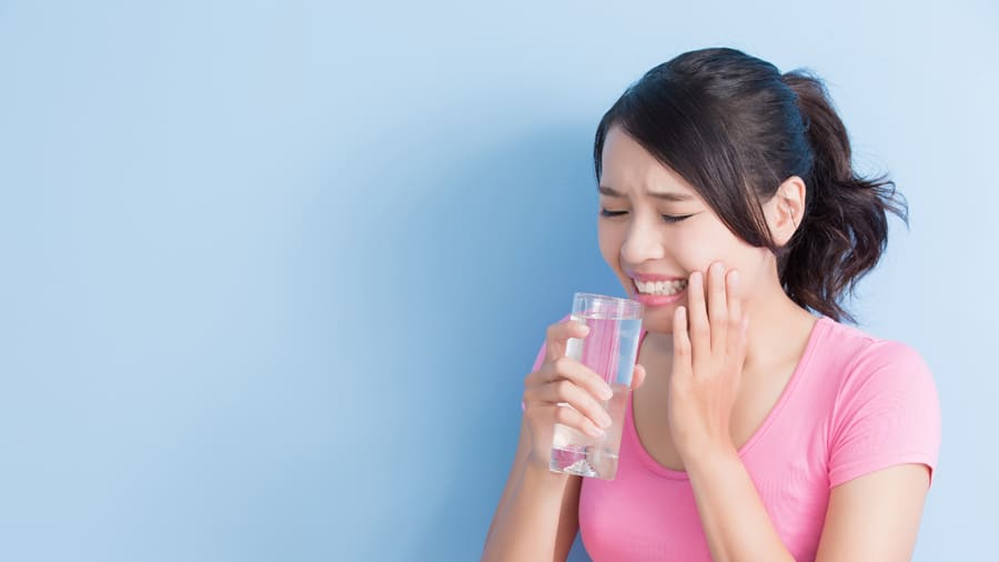 患有敏感牙齒的女性在喝水